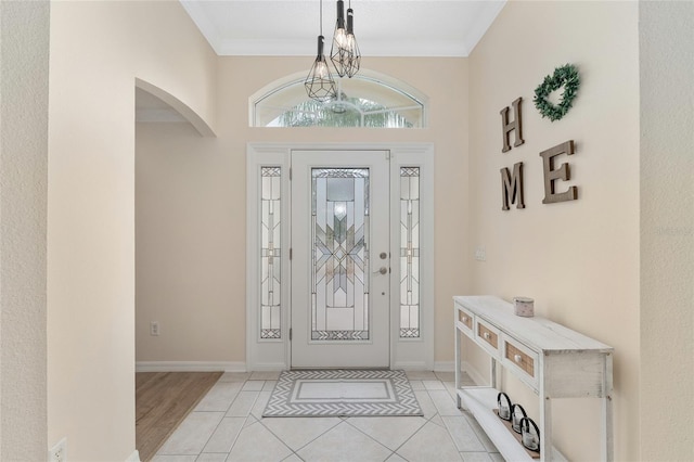 tiled foyer featuring crown molding