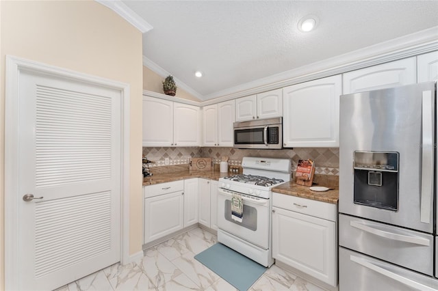 kitchen with stainless steel appliances, white cabinetry, vaulted ceiling, and stone countertops