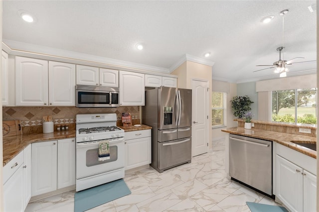 kitchen with ornamental molding, appliances with stainless steel finishes, decorative backsplash, and white cabinets