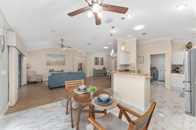 dining space with ceiling fan, ornamental molding, lofted ceiling, and a textured ceiling