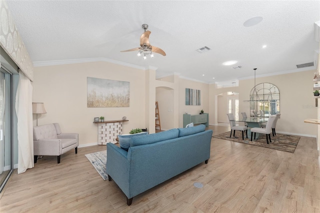 living room with lofted ceiling, ornamental molding, and light hardwood / wood-style floors