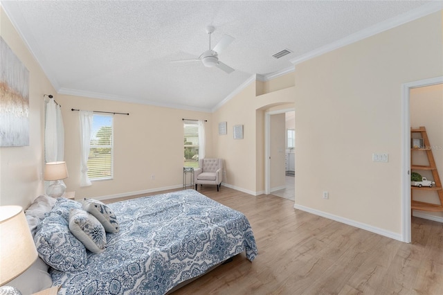 bedroom with crown molding, ceiling fan, a textured ceiling, vaulted ceiling, and light wood-type flooring