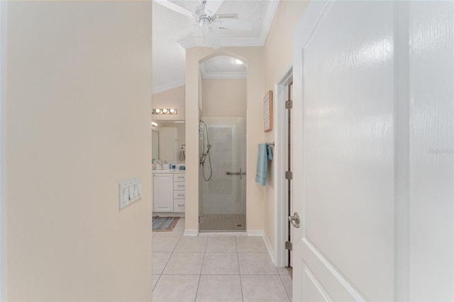 corridor with ornamental molding, sink, and light tile patterned floors