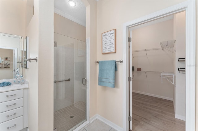 bathroom with an enclosed shower, vanity, hardwood / wood-style floors, and a textured ceiling