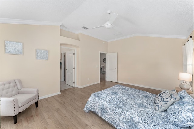 bedroom featuring crown molding, lofted ceiling, light hardwood / wood-style floors, and a textured ceiling