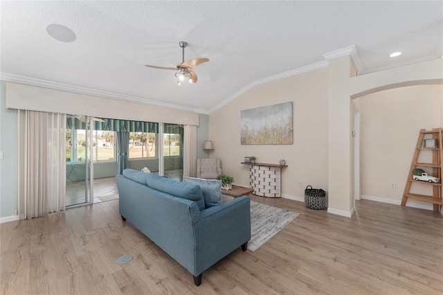 living room featuring lofted ceiling, crown molding, light hardwood / wood-style floors, and a textured ceiling