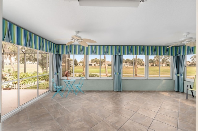 unfurnished sunroom featuring a wealth of natural light and ceiling fan