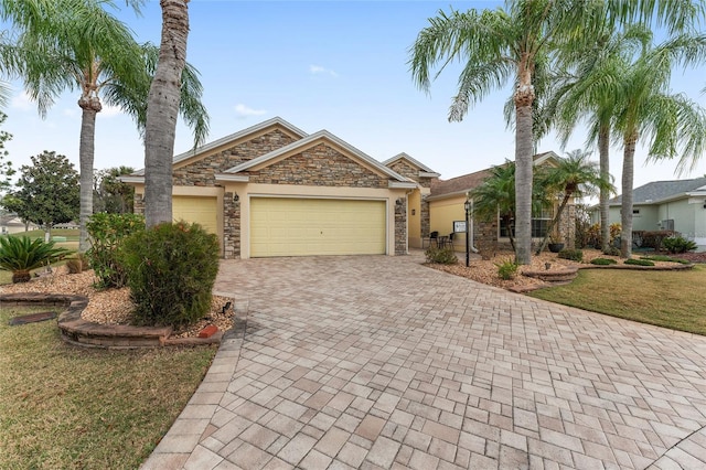 1312 Patrick Pl, The Villages, FL 32162 - single story home with decorative driveway, stone siding, a garage, and stucco siding