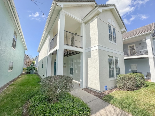 view of home's exterior with a lawn and central air condition unit