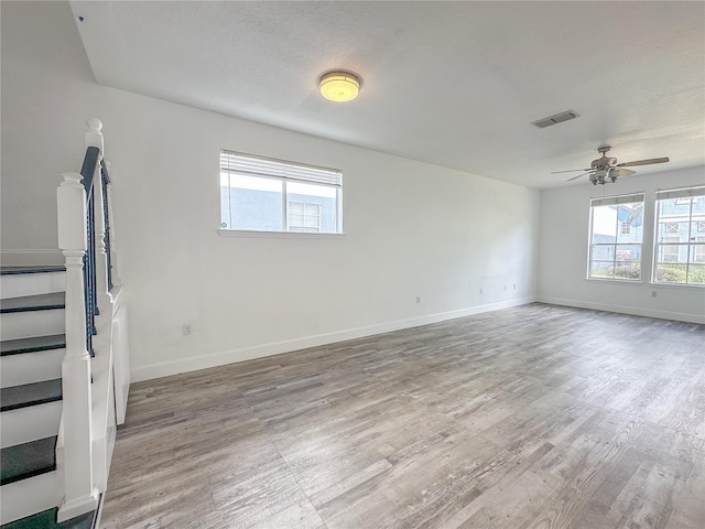 unfurnished room with ceiling fan, a healthy amount of sunlight, and light wood-type flooring