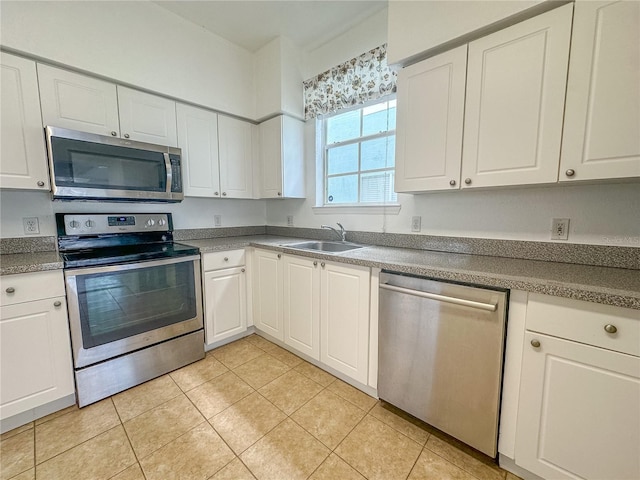 kitchen featuring white cabinetry, appliances with stainless steel finishes, sink, and light tile patterned flooring