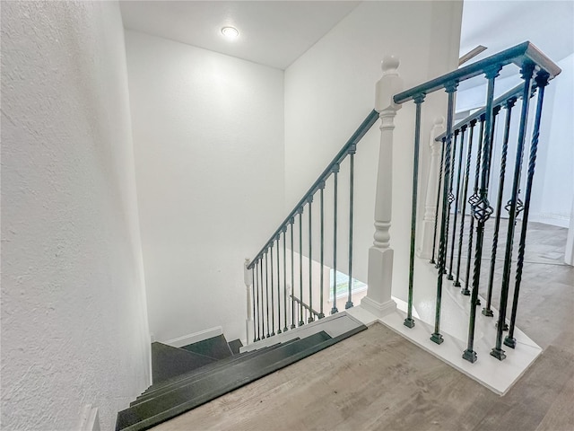 staircase with hardwood / wood-style floors