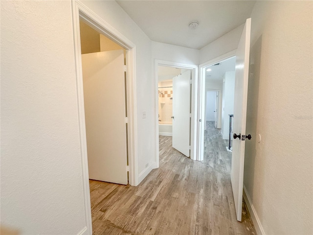 hallway with light hardwood / wood-style flooring