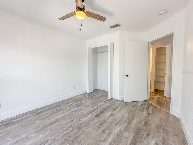 unfurnished bedroom featuring light hardwood / wood-style flooring, a closet, and ceiling fan