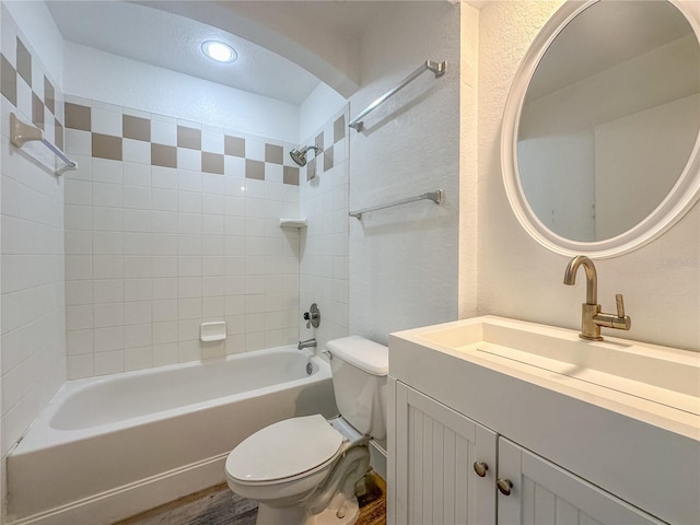 full bathroom with tiled shower / bath, vanity, toilet, and wood-type flooring