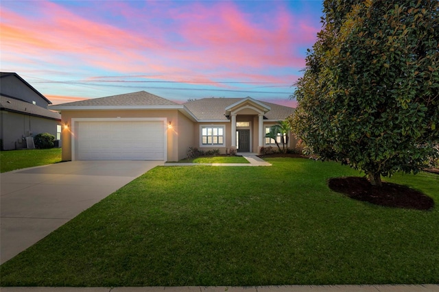 view of front of home featuring a garage and a yard