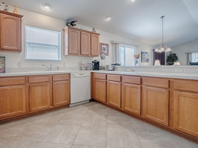 kitchen with a textured ceiling, a sink, light countertops, hanging light fixtures, and dishwasher