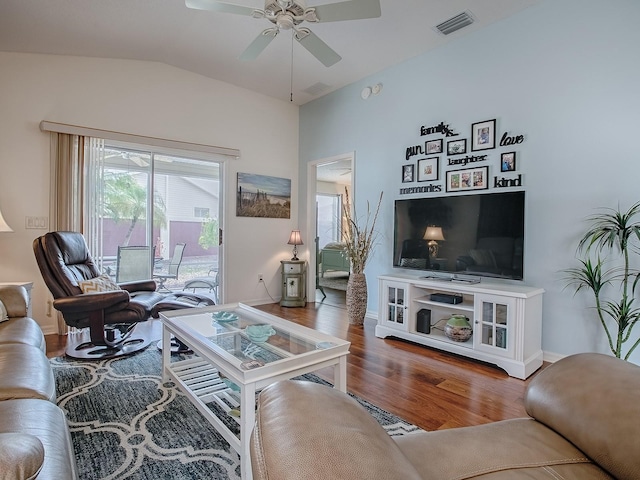 living area with lofted ceiling, wood finished floors, visible vents, baseboards, and a ceiling fan