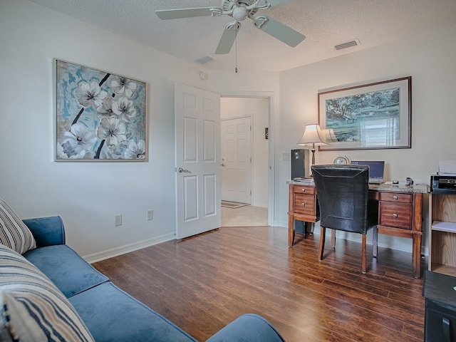 home office with visible vents, a ceiling fan, a textured ceiling, wood finished floors, and baseboards