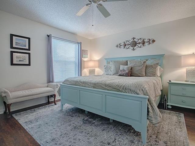 bedroom featuring ceiling fan, dark wood finished floors, and a textured ceiling