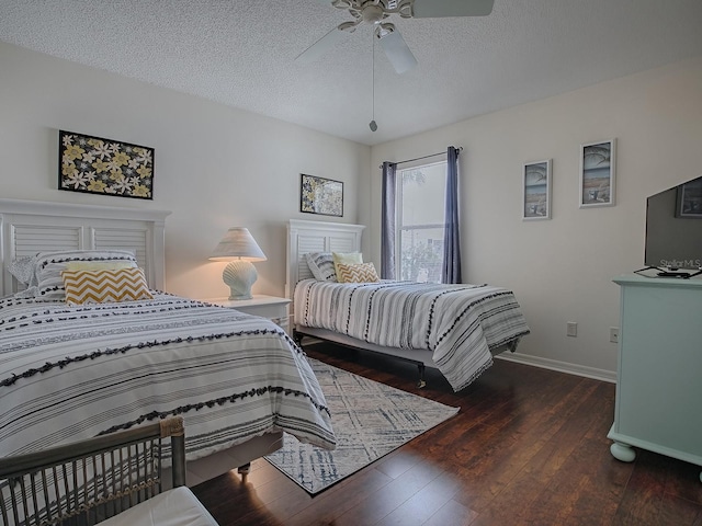 bedroom featuring ceiling fan, baseboards, dark wood finished floors, and a textured ceiling