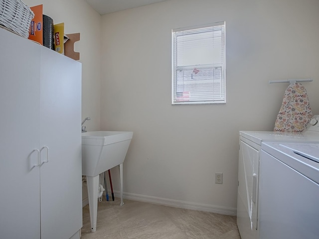 laundry area with laundry area, baseboards, and washing machine and clothes dryer