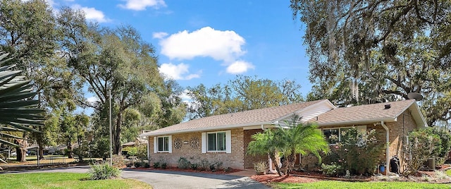 ranch-style house featuring brick siding and a front lawn