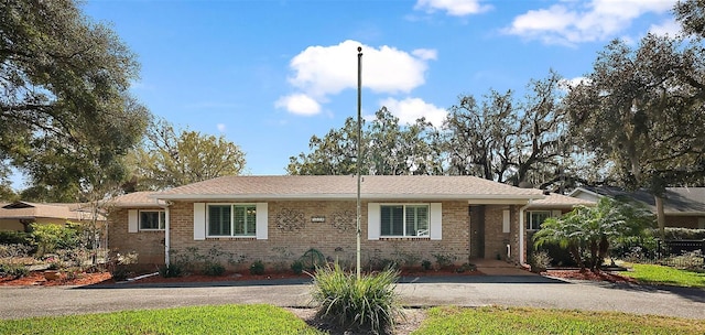 single story home with aphalt driveway and brick siding