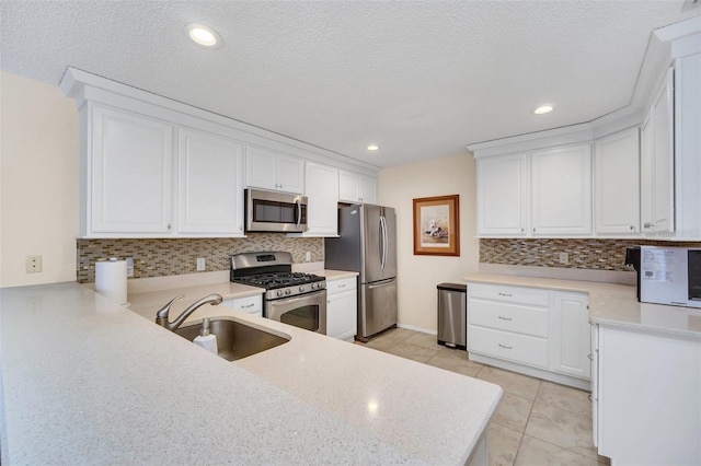 kitchen with a sink, white cabinetry, stainless steel appliances, and light countertops