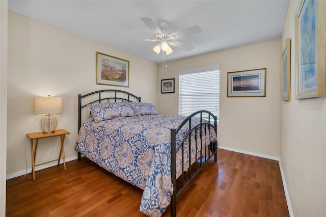 bedroom featuring ceiling fan, baseboards, and wood finished floors