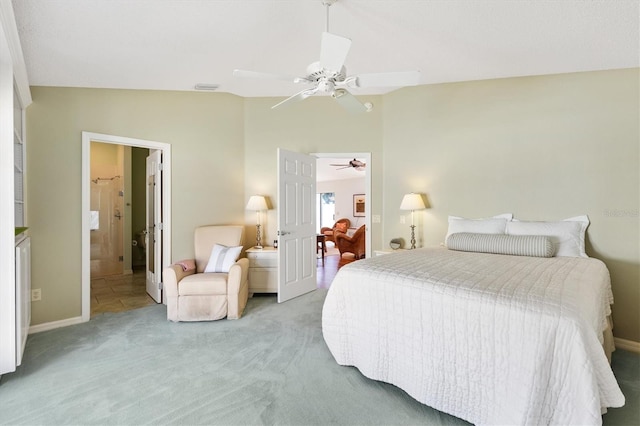 bedroom featuring lofted ceiling, ensuite bathroom, light carpet, visible vents, and a ceiling fan