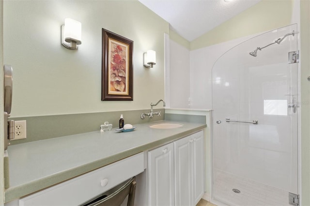 full bathroom featuring a stall shower, lofted ceiling, and vanity