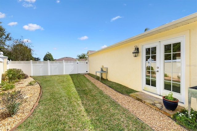 view of yard featuring french doors and a fenced backyard