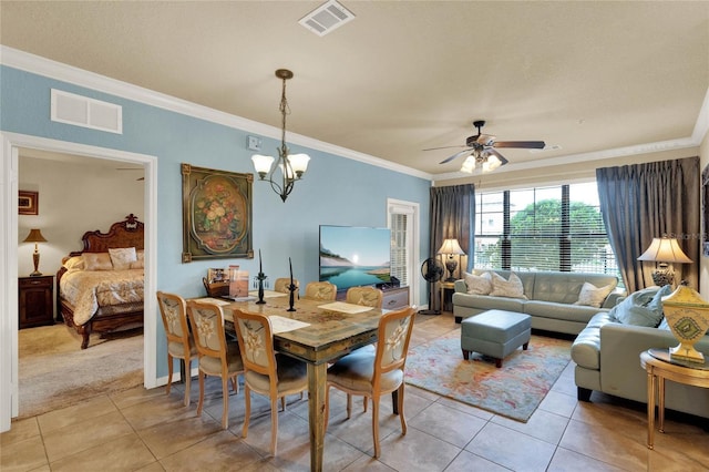 dining area featuring light tile patterned flooring, ornamental molding, and ceiling fan with notable chandelier