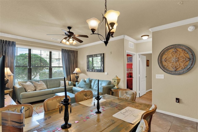 dining area with tile patterned flooring, crown molding, and ceiling fan with notable chandelier