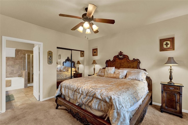 bedroom featuring ensuite bathroom, light colored carpet, ceiling fan, and a closet