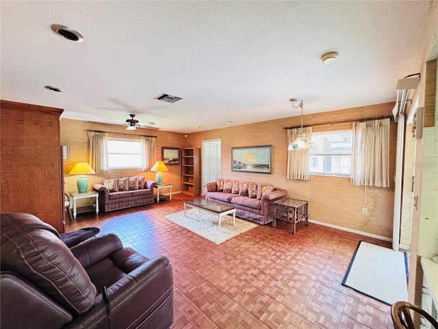 933 Harbor Dr S, Venice, FL 34285 - living room featuring a ceiling fan, a textured ceiling, and baseboards