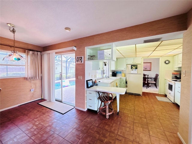 933 Harbor Dr S, Venice, FL 34285 - kitchen featuring white appliances, light countertops, a sink, a peninsula, and under cabinet range hood