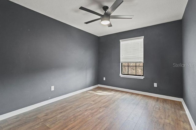 empty room with hardwood / wood-style floors and ceiling fan