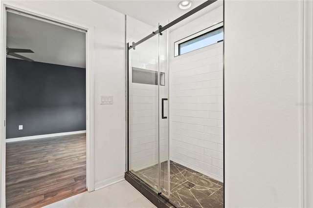 bathroom with wood-type flooring, an enclosed shower, and ceiling fan