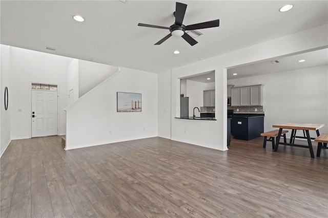 living room featuring dark hardwood / wood-style flooring, sink, and ceiling fan