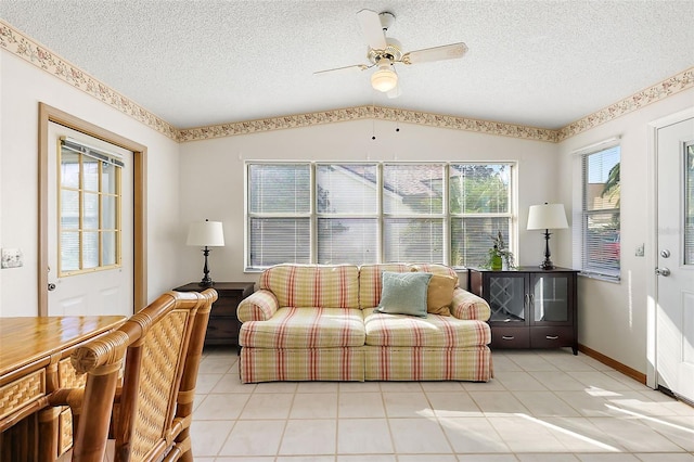 tiled living room featuring ceiling fan, a textured ceiling, and lofted ceiling