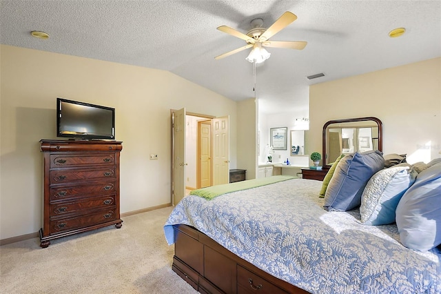 bedroom with a textured ceiling, vaulted ceiling, light colored carpet, and ceiling fan