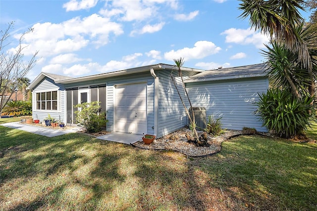back of house with a yard and a garage