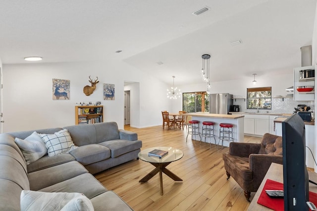 4723 Crk 306, Lake Panasoffkee, FL 33538 - living room featuring lofted ceiling, light hardwood / wood-style flooring, and a notable chandelier
