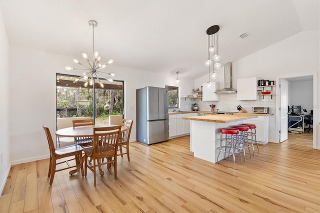 4723 Crk 306, Lake Panasoffkee, FL 33538 - kitchen with wood counters, white cabinetry, stainless steel fridge, and decorative light fixtures