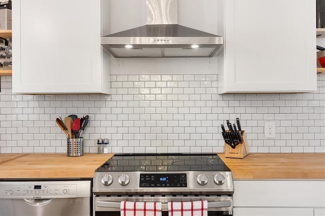 4723 Crk 306, Lake Panasoffkee, FL 33538 - kitchen with butcher block counters, backsplash, white cabinetry, stainless steel appliances, and wall chimney exhaust hood