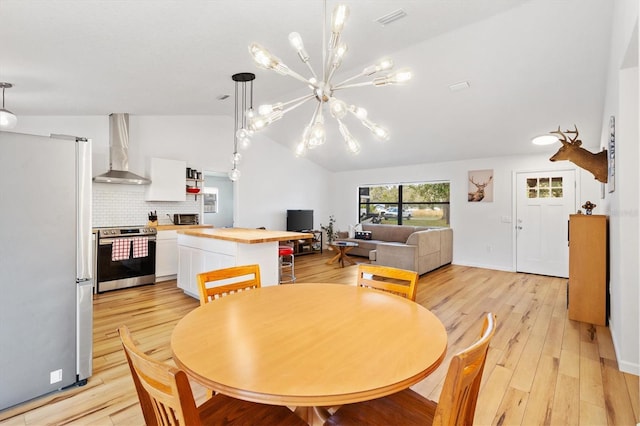 4723 Crk 306, Lake Panasoffkee, FL 33538 - dining space with lofted ceiling, a chandelier, and light hardwood / wood-style flooring