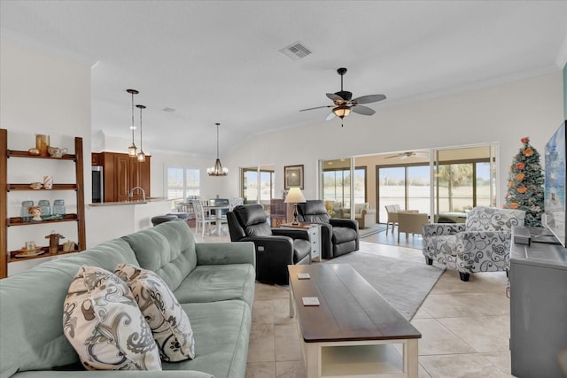 tiled living room featuring lofted ceiling, crown molding, and ceiling fan with notable chandelier