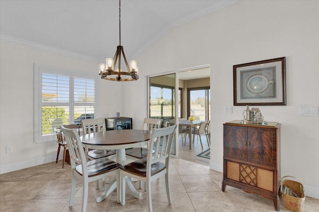 dining room featuring an inviting chandelier, a healthy amount of sunlight, vaulted ceiling, and light tile patterned floors